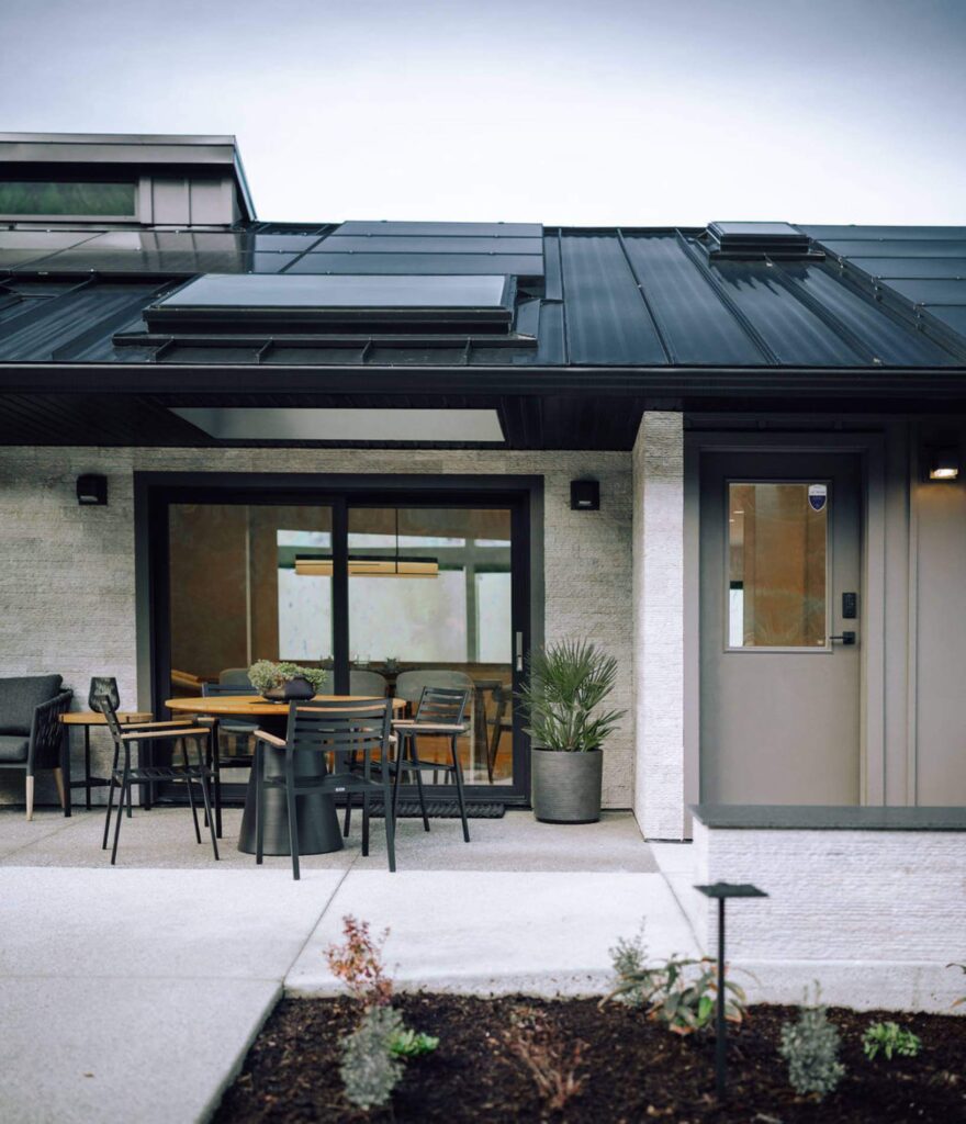 Outdoor patio space with metal chairs and garden