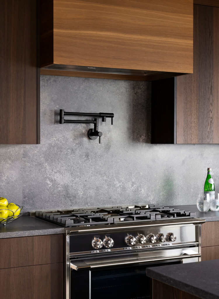 Close up view of gas range and custom hood