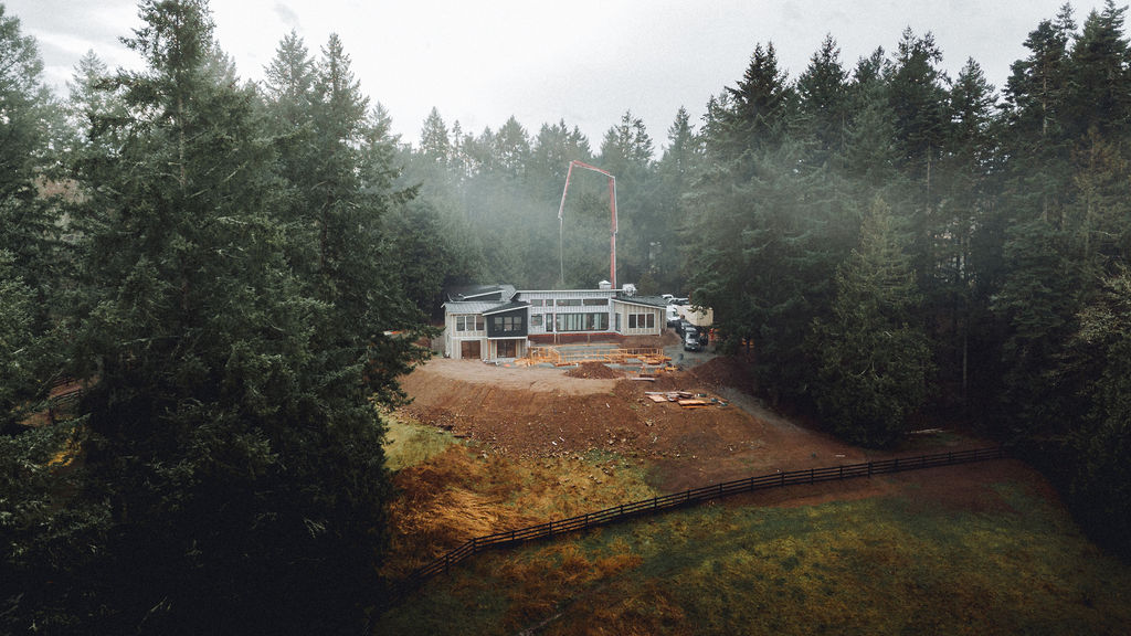 Aerial photo of house on hill with trees and crane